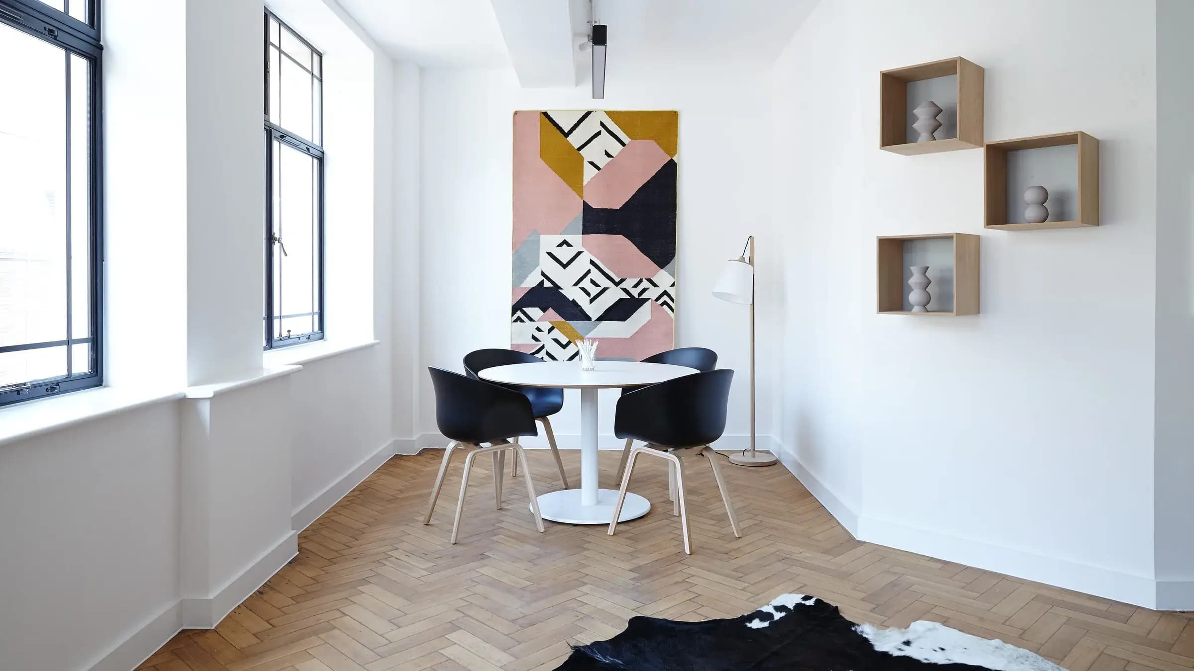 Ruang makan putih dengan lantai kayu herringbone